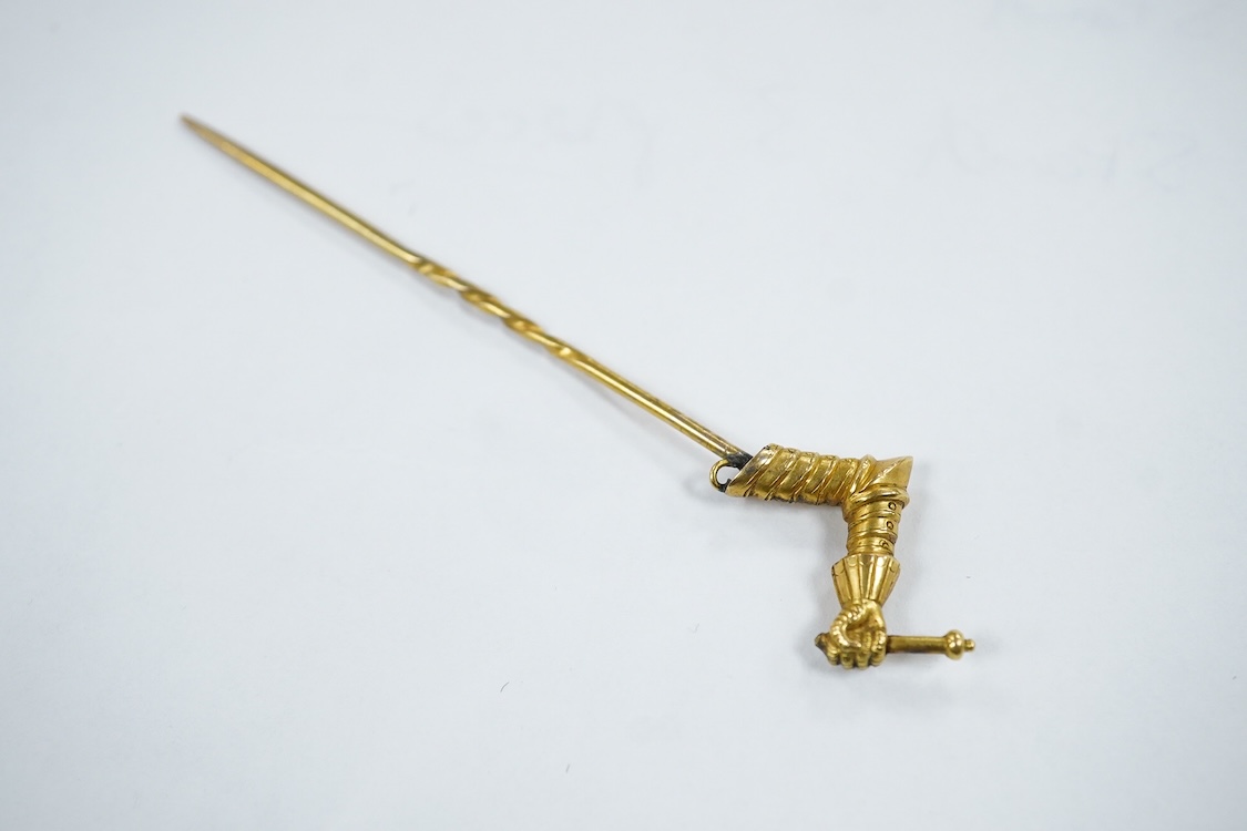 A yellow metal stick pin, the terminal modelled as a Knight's arm holding a scroll(a.f.), 79mm, together with two pairs of yellow metal and gem set ear clips including 9ct and opal doublet.